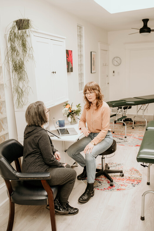 A woman having a Patient Consultation to discuss the best approach to help her body to heal.  Chiropractic, Naturopathic Medicine, Acupuncture in Toronto.