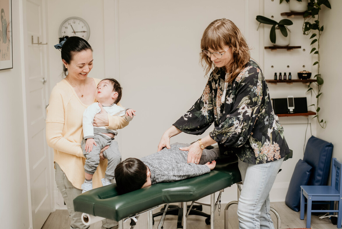 Young family being adjusted by chiropractor at Vivid Health in Toronto.  Chiropractic for kids in Toronto.